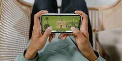 person playing a cricket game on an iphone