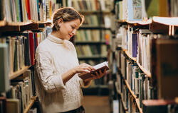 woman holding a book inside the library