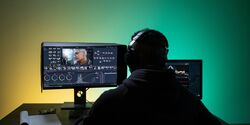 a man sitting in front of laptop while editing a video