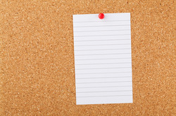 Note Paper On Cork Board: A blank note paper on a cork board