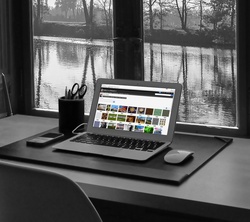 Home Office Desktop with laptop and view out the windows of a river
