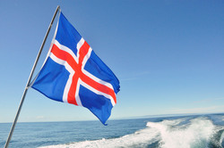 Iceland flag waving with the sea and sky in the background