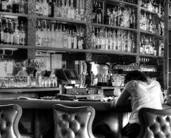 Black and white photo of despondent woman at a bar