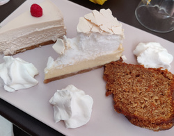 Picture of some delicious cakes: a piece of cheesecake raspberry and basil, a piece of lemon tart with meringue and a piece of carrot cake)