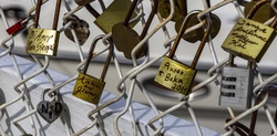 Assorted gold love padlocks hung by the local community on a wire fence