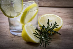 Lemonade with fresh lemon on wooden background