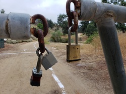 Three padlocks on a metal pipe gate
