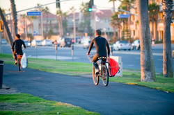 Surfer of the bicycle at Huntington Beach