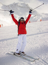 Happy female skier with her hands up