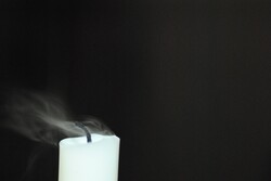 Flame of a candle blown out by the wind