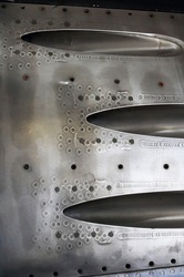 Machine gun ports on the side of a polished metal Finnish sabre jet