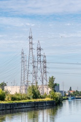 Photo landscape of the Belgian river, the Scheldt, with overhanging high-voltage pylons, standing photo