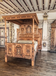 Antique luxury canopy bed in a vintage richly decorated bedroom