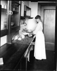 Miss Ruth Kellogg demonstrating correct postures for housework