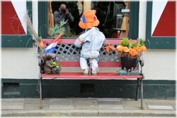 Little person (pop) looking through cafe window and sees the photographer