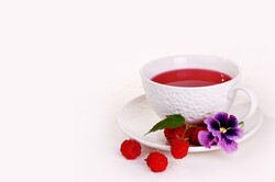 White mug with tea and raspberry