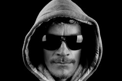 Man with hoodie and sunglasses on black background