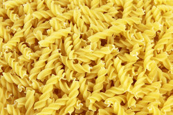 Uncooked dry yellow fusilli pasta as a background 