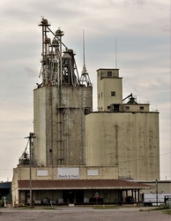 An old feed mill on a blue sky background.