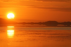 Bright Sun above Vancouver Point, mirrored in Princess Royal Harbour