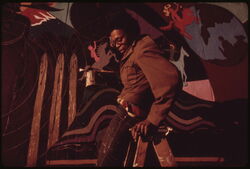 Artist Ron Blackburn painting an outdoor wall mural